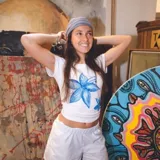 Remera blanca de algodón con manga corta y estampado de flores azules pintadas a mano.