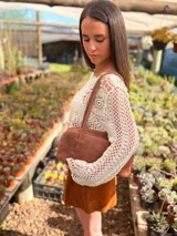 Cartera baguette de cuero color marrón con forro interno de tela.