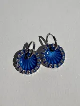 Par de aros colgantes con argolla de acero quirúrgico y dije circular de resina azul con strass plateados.