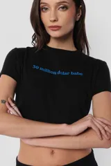 Remera negra de jersey, corte baby tee con cuello alto de ribb complemento y estampa frontal con la frase "30 million dolar babe" en color celeste.