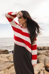 Sweater tejido a rayas rojas y blancas con cuello a la base en crochet. Mangas caídas, largo por la cadera.