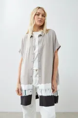 Vestido camisero color beige con detalle de teñido tie dye en blanco y negro en el ruedo.
