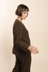 Cardigan tejido con efecto fantasia color crema. Una prenda de silueta amplia y cómoda. Tejido en 100% lana fina sin teñir.