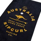 Toalla de playa negra con estampado en color dorado que incluye el logo de Rip Curl, un canguro y la frase "Road Trippin' Down Under".