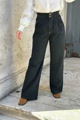Pantalón de jean negro de corte ancho, recto y tiro alto. Tiene elástico y pinzas en la pretina.
