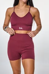 Conjunto deportivo color borgoña compuesto por un top con breteles finos y logo "bk." estampado en blanco, y un short de calce ajustado.