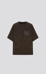 Remera de manga corta y cuello redondo, corte oversize, color marrón oscuro con efecto batik/lavado. Presenta el número "90" estampado en el pecho en un tono ligeramente más oscuro.