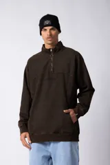 Buzo marrón de frisa 100% algodón con medio cierre, bordado al tono y calce oversize. Tiene un lavado snow que le da un aspecto gastado.