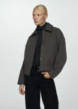 Chaqueta marrón de punto con cuello camisero, cierre de botones a presión ocultos, dos bolsillos laterales, terminación elástica, diseño oversize y manga larga.