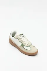 Zapatillas urbanas de gamuza color beige, blanco y verde, con recortes en símil cuero y suela de goma marrón de 2,5 cm de altura.