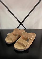 Sandalias planas color beige, con dos tiras anchas ajustables con hebilla y suela de corcho.
