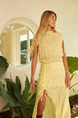 Conjunto de falda midi confeccionada en gasa color amarillo pálido, con ajuste de frunce delantero que permite regular el largo.