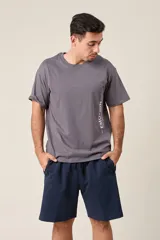 Bermuda deportiva gris de nylon, de corte suelto, con cintura elástica y cordón de ajuste. Cuenta con detalles de líneas negras en los costados y bolsillos laterales con cierre.