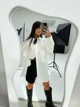 Camisa oversize color beige de manga larga con bolsillos frontales.