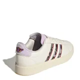 Championes Adidas Grand Court 2.0 color crema con las tres tiras laterales estampadas con diseño de mariposas y flores. Detalles en color lila en el talón, lengüeta y cordones.