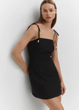 Vestido corto de lino color fucsia, con tirantes finos y escote recto.