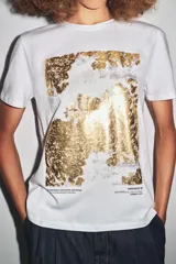 Camiseta blanca de corte recto y manga corta, con estampado frontal de una fotografía en blanco y negro y texto "Amsterdam 74".