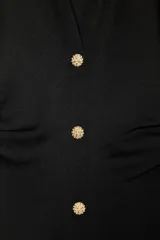 Vestido midi color gris topo, de cuello camisero y escote pico con manga corta. Tiene detalle de drapeado lateral y cierre frontal con botones metálicos.