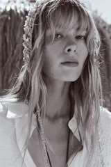 Camisa blanca de manga larga con cuello solapa y bordado de flor en el frente.