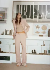 Pantalón de vestir color beige, de corte recto, con bolsillos laterales y traseros. Se ajusta a la cintura con botón y cierre.