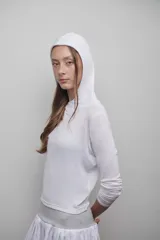 Camiseta blanca de manga larga confeccionada en tejido fino, suave y ligero. Presenta capucha amplia y silueta relajada.