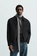 Sobrecamisa de hombre regular fit confeccionada en tejido con estructura irregular en tonos beige, marrón y negro. Tiene cuello solapa, manga larga con puños abotonados, bolsillos laterales y cierre frontal con cremallera.