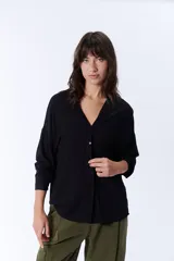 Blusa negra de manga larga con escote en V y cierre frontal con botones.