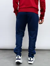 Pantalón de entrenamiento azul marino con logo de Umbro en blanco, corte ajustado y detalles en azul brillante en los tobillos.