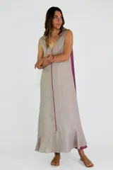 Vestido largo color beige con corte en la cintura, escote en V, sin mangas y abertura lateral.