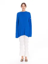 Buzo oversized de color azul, con cuello subido tipo polerita y cortes laterales.