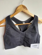Top deportivo gris oscuro con espalda estilo racerback y banda elástica acanalada en el bajo busto.