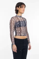 Remera de mangas largas, cuello alto y corte ajustado, confeccionada en tejido de red transparente con estampado de piel de serpiente en tonos grises y marrones.