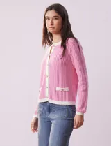 Cardigan de punto color beige con textura tipo tweed, escote redondo, cierre frontal con botones dorados y bolsillos simulados.