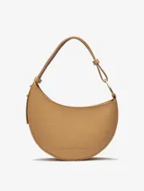 Bolso de hombro tipo media luna color camel, con textura granulada y asa corta regulable.