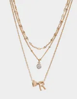 Collar corto dorado multicadena con dije de corazón y letra R.
