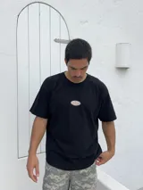 Remera negra de corte boxy con parche bordado en el pecho.