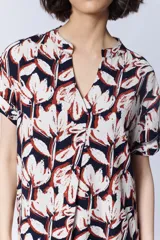 Vestido camisero corto con estampado de flores en tonos blanco, azul marino y rojo.