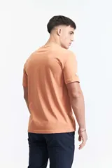 Remera color salmón de manga corta con cuello redondo y estampado en el pecho.