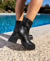 Botas cortas de cuero negro, con cierre lateral, taco de madera forrado en cuero y suela de goma.