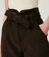 Pantalón clochard de terciopelo color marrón chocolate, con cintura alta, bolsillos laterales y cinturón de lazo.