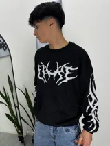 Sweater negro de punto con cuello redondo y estampado blanco con tipografía gótica en el frente y en las mangas. Corte holgado.