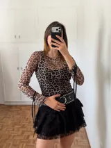 Remera de tul con estampado animal print de leopardo, mangas largas con tiras y cuello redondo.