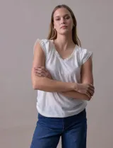 Remera blanca de modal con escote en V y detalle de puntilla en mangas y escote.