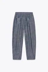 Pantalón jogger azul de lino con tiro alto, cintura elástica en la espalda, bolsillos delanteros y traseros, y cierre frontal con cremallera y botón.