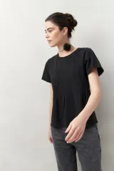 Remera blanca de manga corta con cuello redondo y costuras verticales en el frente.