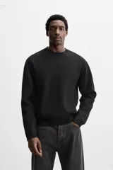 Sweater negro de punto con cuello redondo y mangas largas.