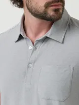 Remera polo azul jaspeado con bolsillo en el pecho y botones en el cuello. Confeccionada con fibras recicladas y spandex con tecnología Natural Flex.