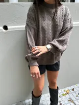 Sweater tejido negro con cuello redondo y diseño de ochos.