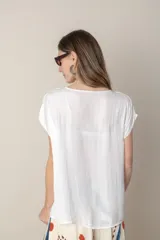 Blusa fucsia de seda con escote en V y mangas cortas.