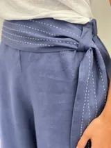 Pantalón de lino color gris claro, de corte amplio y cintura alta.